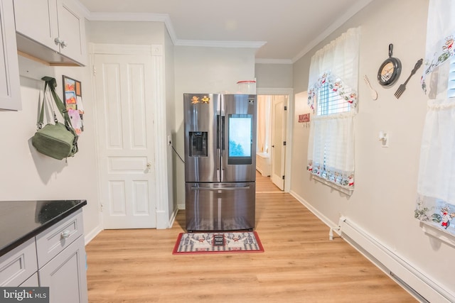 kitchen featuring stainless steel refrigerator with ice dispenser, light wood-type flooring, baseboard heating, crown molding, and white cabinets