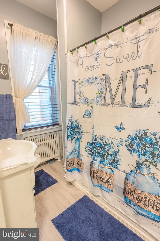 bathroom featuring radiator, shower / bath combo, vanity, and hardwood / wood-style flooring