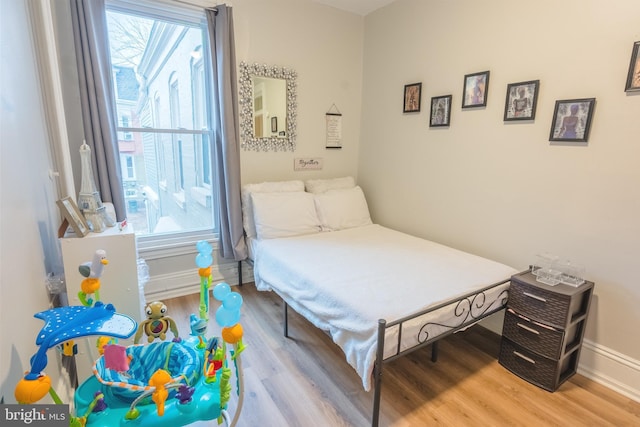 bedroom with wood-type flooring and multiple windows