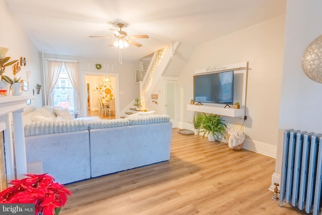 living room with ceiling fan, hardwood / wood-style flooring, and radiator heating unit