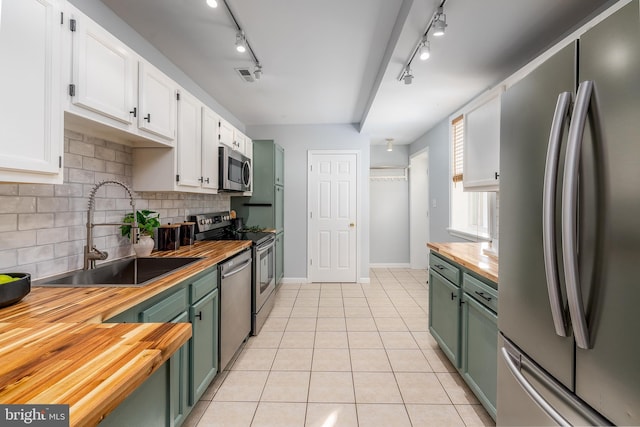 kitchen with wooden counters, sink, green cabinets, white cabinetry, and appliances with stainless steel finishes