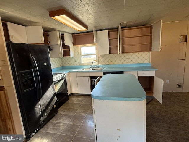 kitchen featuring black appliances, sink, white cabinetry, and a center island