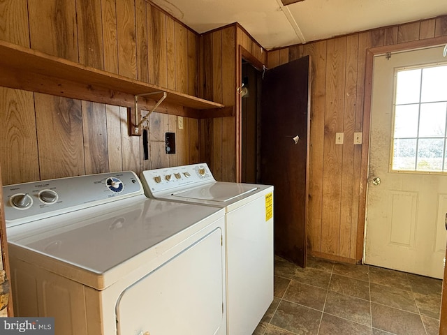 washroom with wood walls and washing machine and clothes dryer