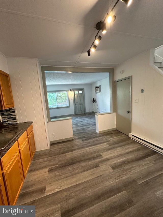 kitchen with dark hardwood / wood-style flooring, sink, track lighting, and a wall mounted air conditioner