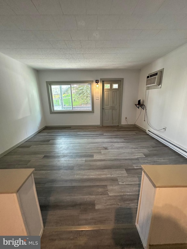 entryway with baseboard heating, dark hardwood / wood-style floors, and a wall unit AC