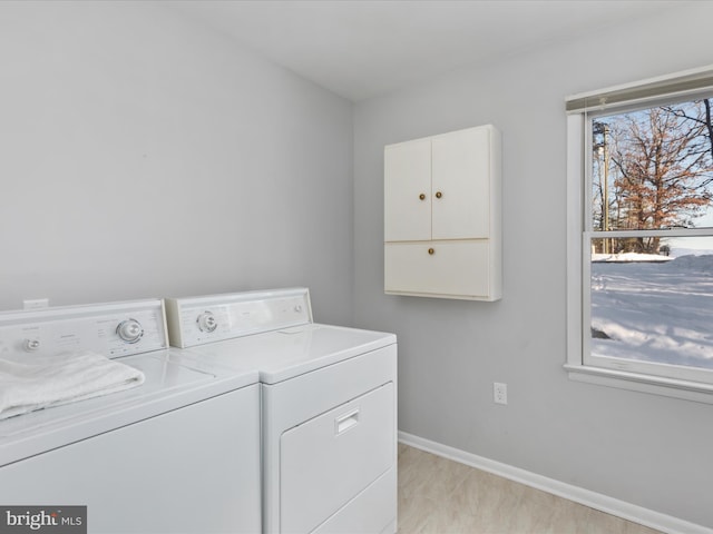 clothes washing area featuring a wealth of natural light and separate washer and dryer