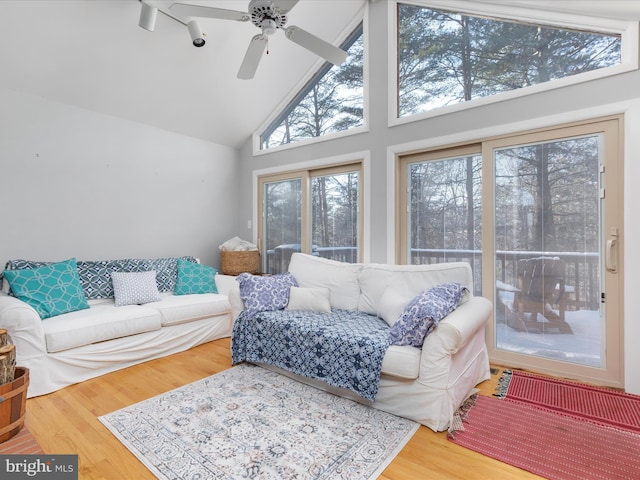 living room featuring hardwood / wood-style flooring, high vaulted ceiling, and ceiling fan