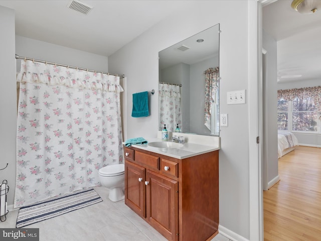 bathroom with toilet, vanity, and hardwood / wood-style floors