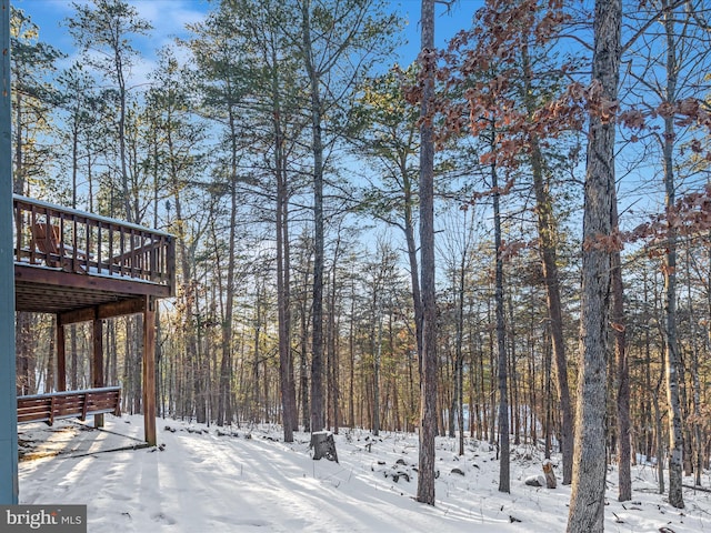 yard covered in snow featuring a wooden deck