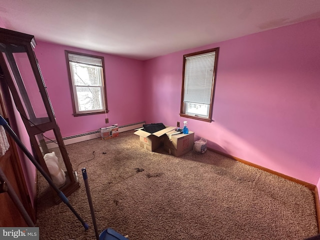 interior space with a baseboard heating unit and carpet flooring