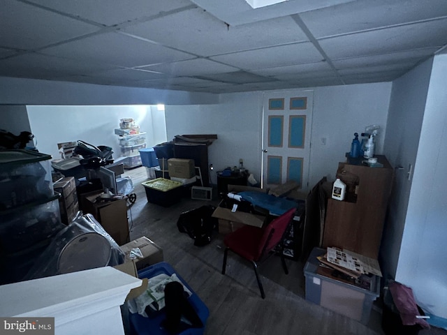 basement featuring a paneled ceiling and hardwood / wood-style floors