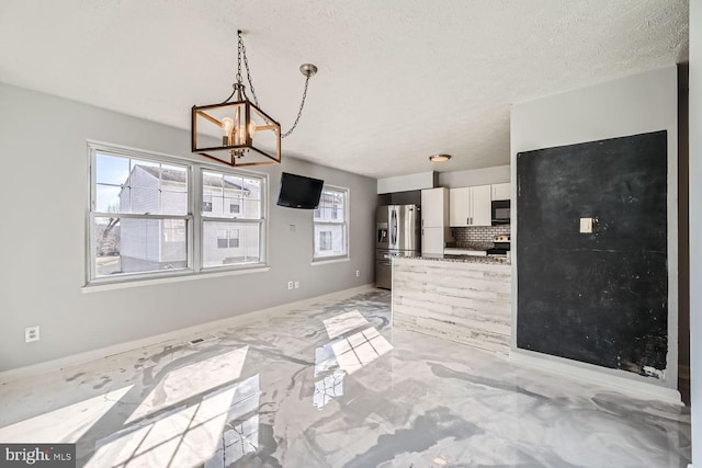 kitchen with white cabinetry, decorative light fixtures, plenty of natural light, stainless steel appliances, and backsplash