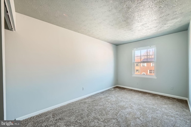 spare room with a textured ceiling and carpet