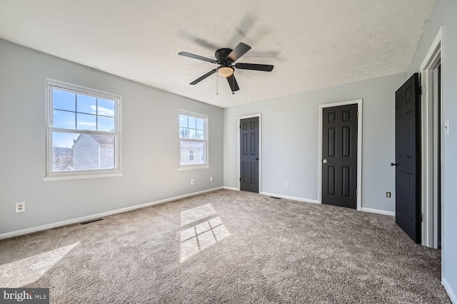 unfurnished bedroom with ceiling fan, a textured ceiling, and carpet flooring