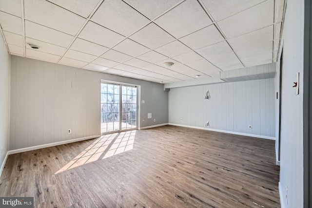 spare room with hardwood / wood-style flooring and a paneled ceiling