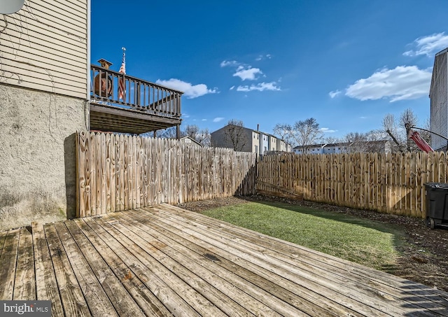 wooden deck featuring a lawn