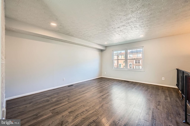 unfurnished living room with dark hardwood / wood-style floors and a textured ceiling