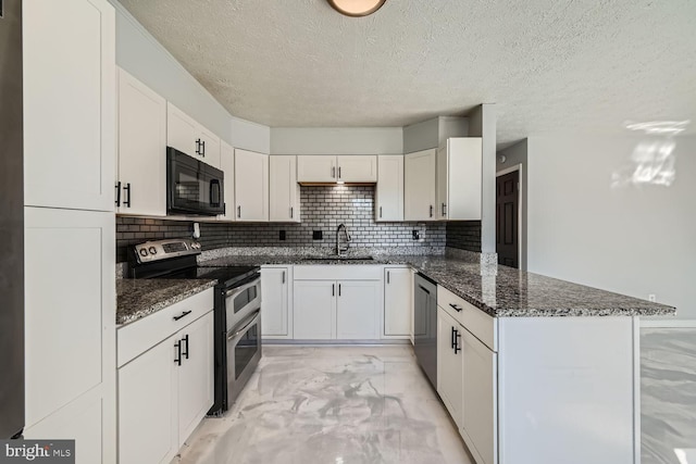 kitchen featuring sink, stainless steel appliances, kitchen peninsula, white cabinets, and dark stone counters