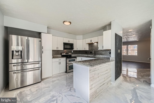 kitchen featuring sink, white cabinetry, dark stone countertops, appliances with stainless steel finishes, and kitchen peninsula