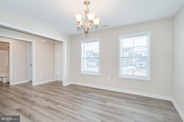 unfurnished dining area featuring light hardwood / wood-style floors and a notable chandelier