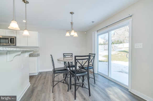 dining area with hardwood / wood-style floors and a chandelier