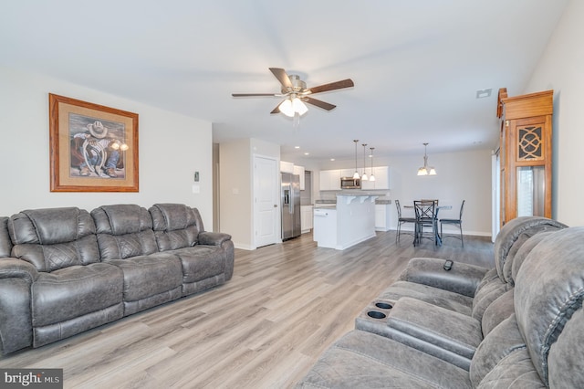 living room featuring light wood-type flooring and ceiling fan