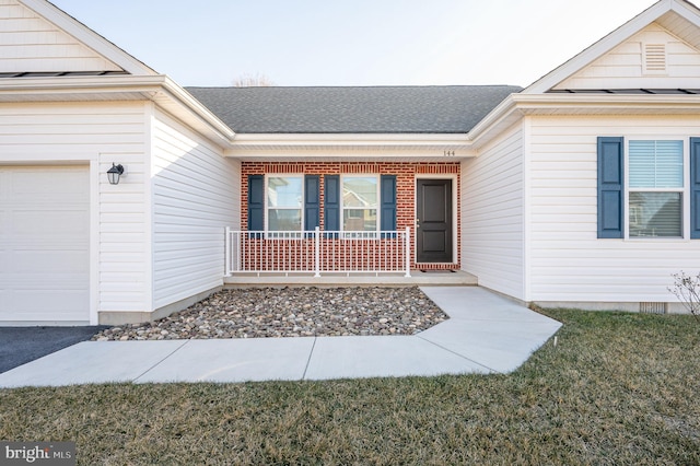 doorway to property with a garage, a lawn, and a porch