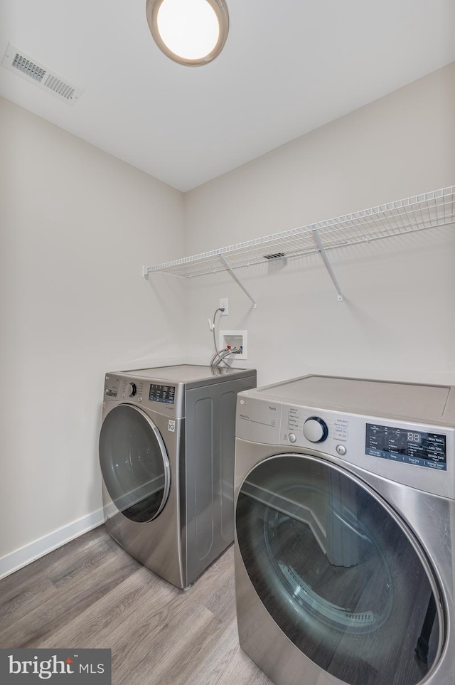 washroom featuring washing machine and dryer and hardwood / wood-style floors