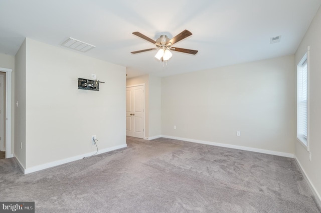 spare room featuring light carpet and ceiling fan