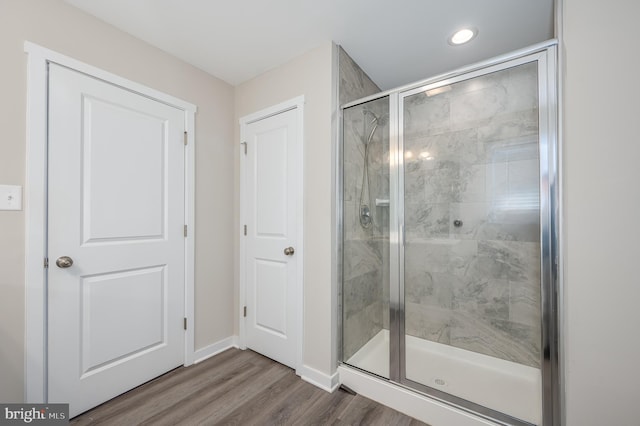 bathroom featuring a shower with shower door and hardwood / wood-style flooring