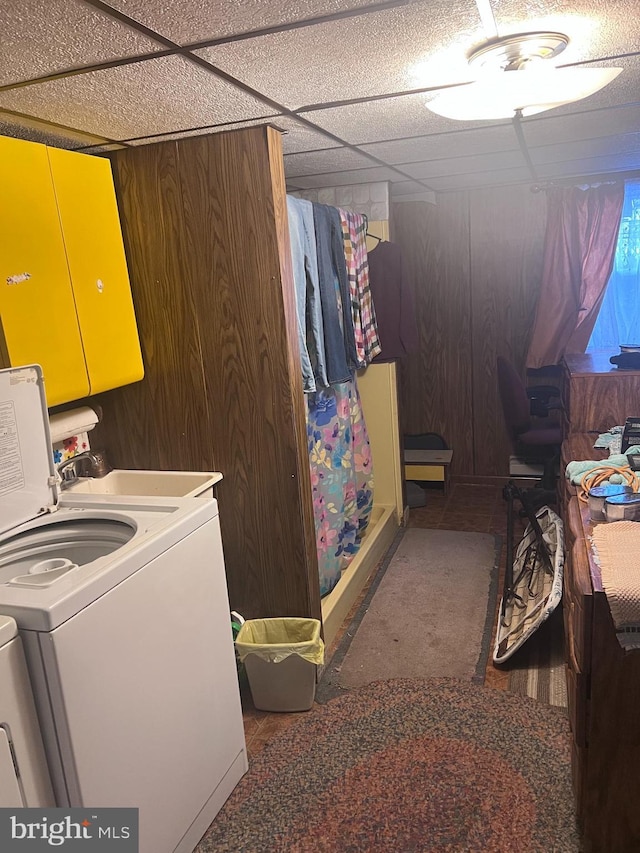 laundry room featuring cabinets, washer and dryer, and wooden walls