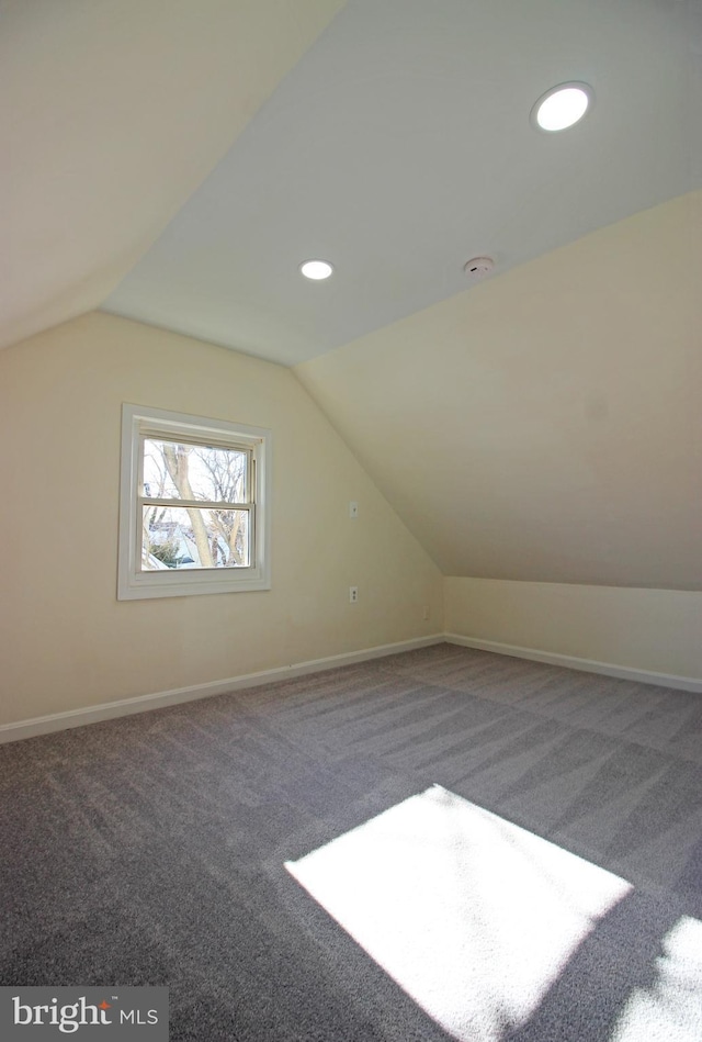 bonus room with vaulted ceiling and carpet