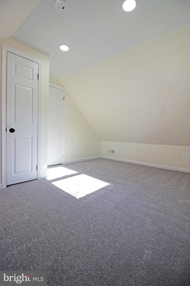 additional living space with lofted ceiling and carpet flooring