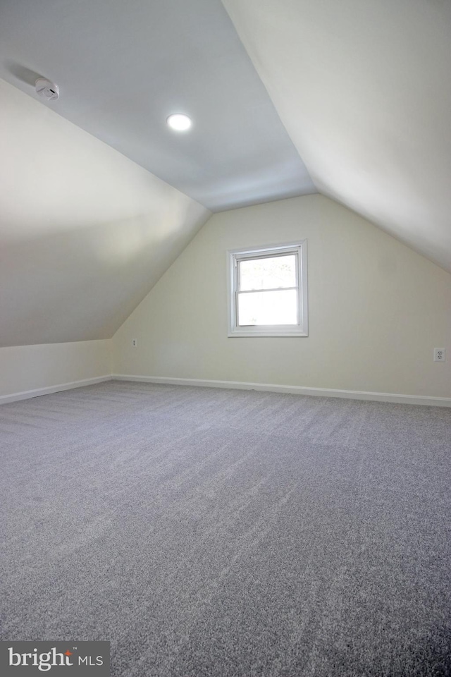 bonus room with vaulted ceiling and carpet