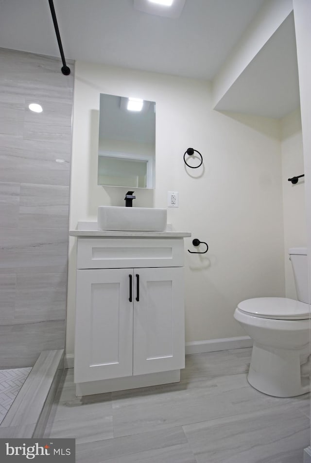 bathroom featuring toilet, vanity, and walk in shower