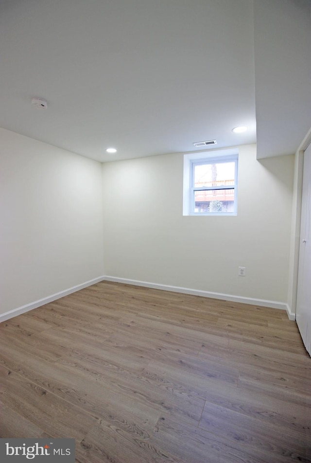 basement with light hardwood / wood-style flooring