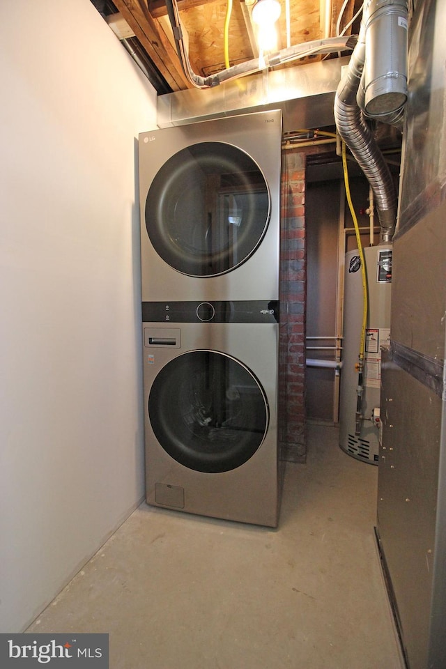 clothes washing area with water heater and stacked washer / dryer