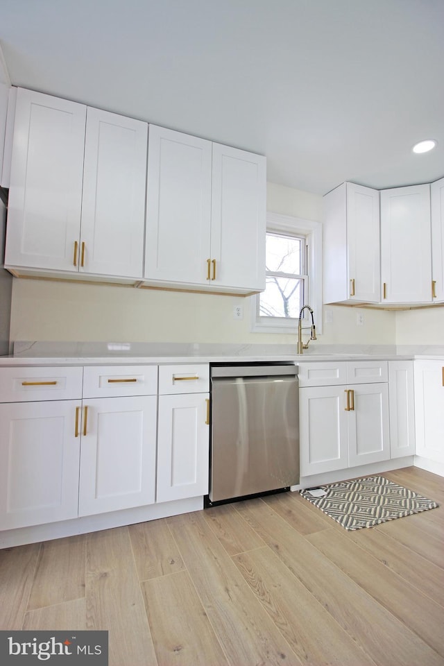 kitchen featuring light wood-type flooring, dishwasher, and white cabinets