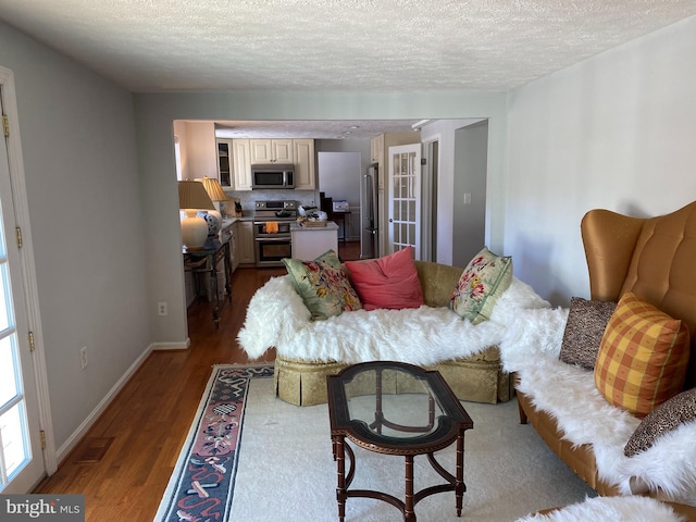 living room featuring a textured ceiling and light wood-type flooring