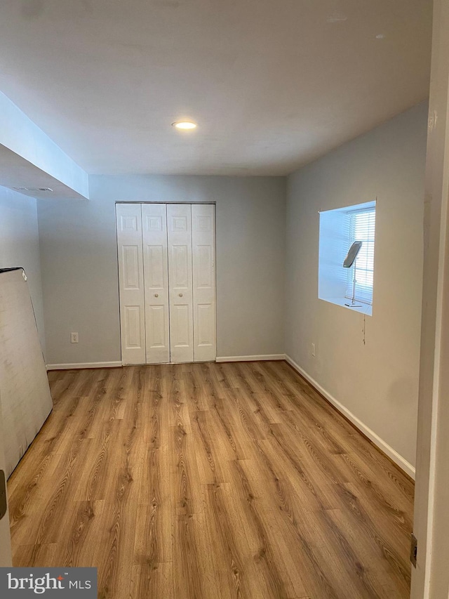 unfurnished bedroom featuring a closet and light hardwood / wood-style flooring