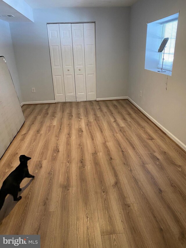 unfurnished bedroom featuring light wood-type flooring and a closet