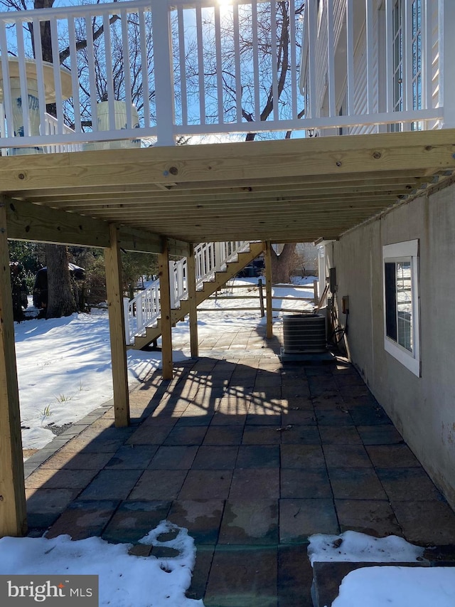 snow covered patio with central air condition unit