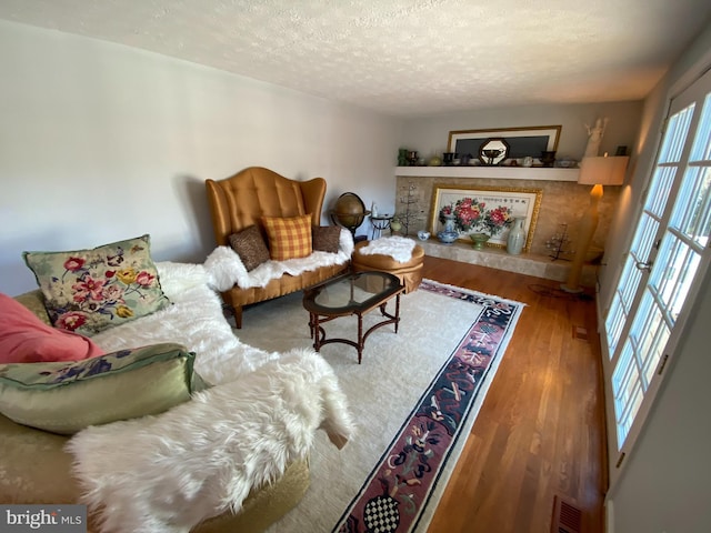 living room with a textured ceiling and hardwood / wood-style flooring