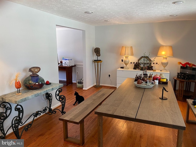 interior space with a textured ceiling and hardwood / wood-style floors