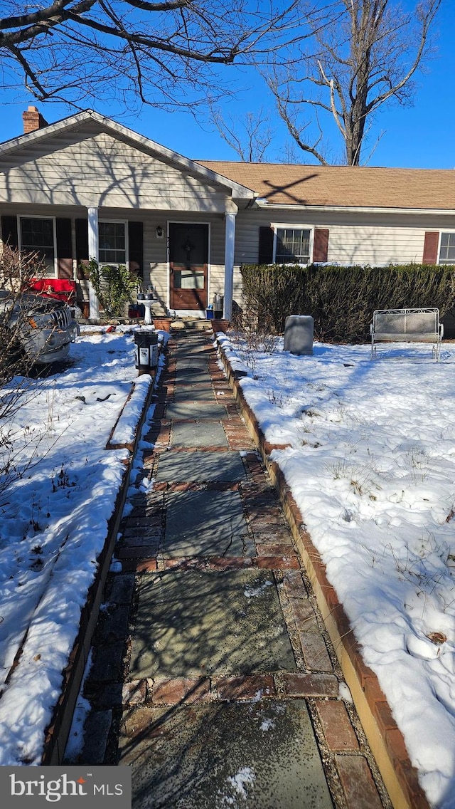 view of snow covered rear of property