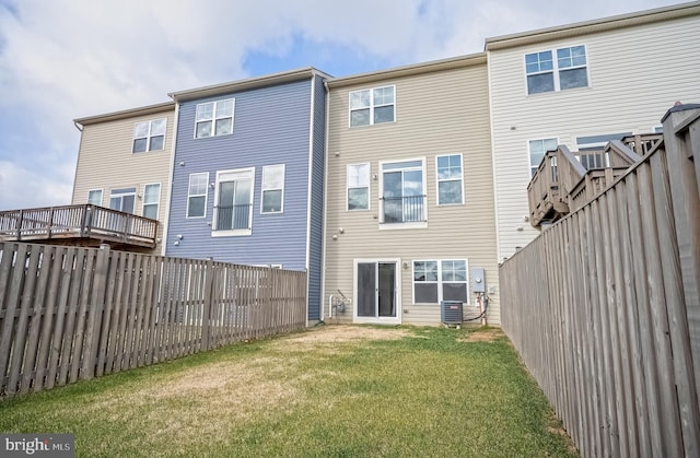 rear view of property featuring central AC unit and a yard