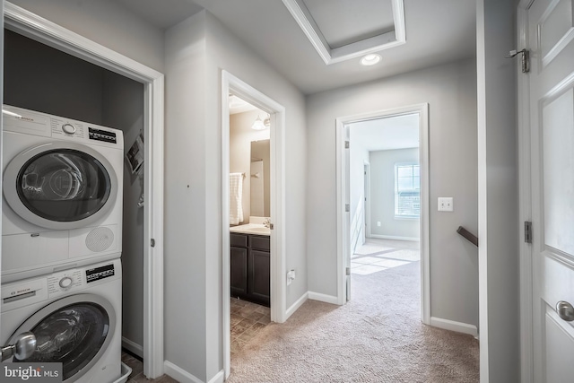 laundry room with stacked washer and dryer and light carpet