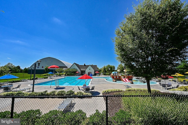 view of swimming pool with a playground and a patio area