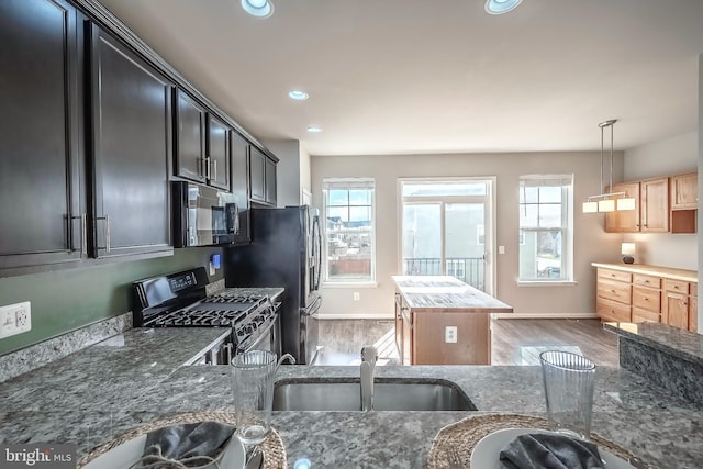 kitchen with decorative light fixtures, a healthy amount of sunlight, sink, and gas range