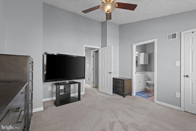 bedroom with connected bathroom, ceiling fan, a textured ceiling, and light colored carpet